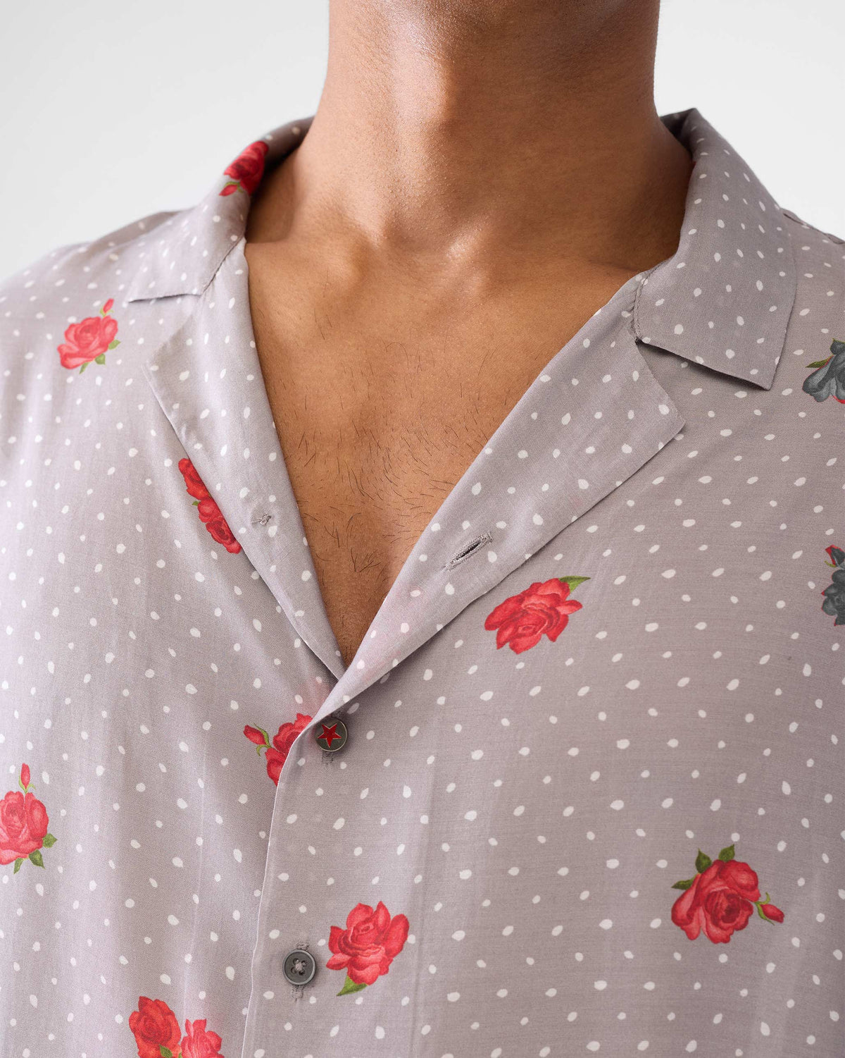 Close-up of a charcoal Mistari Shirt showing red roses and white polka dots.