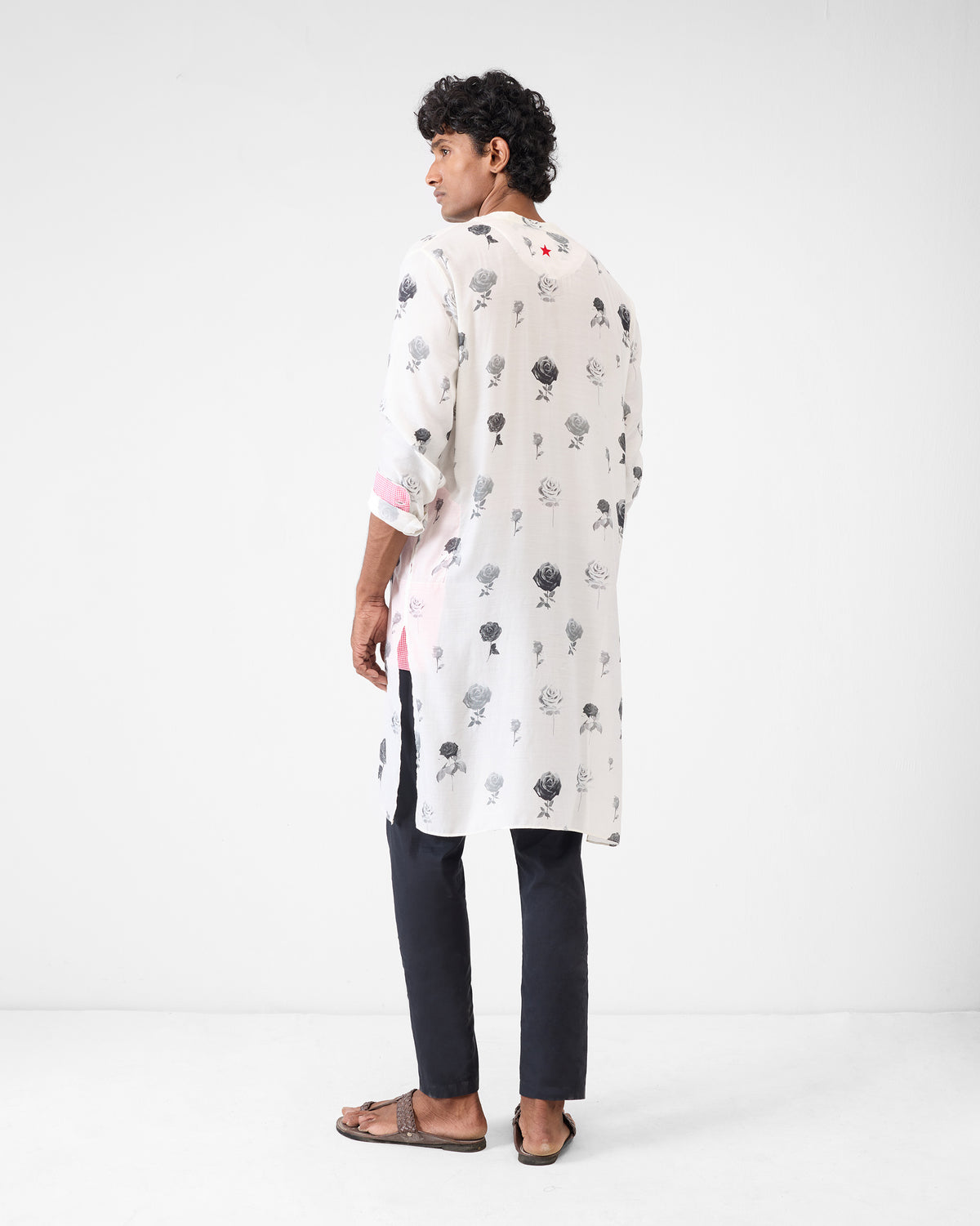 Back of a light grey Astral kurta with rose print and a red star.
