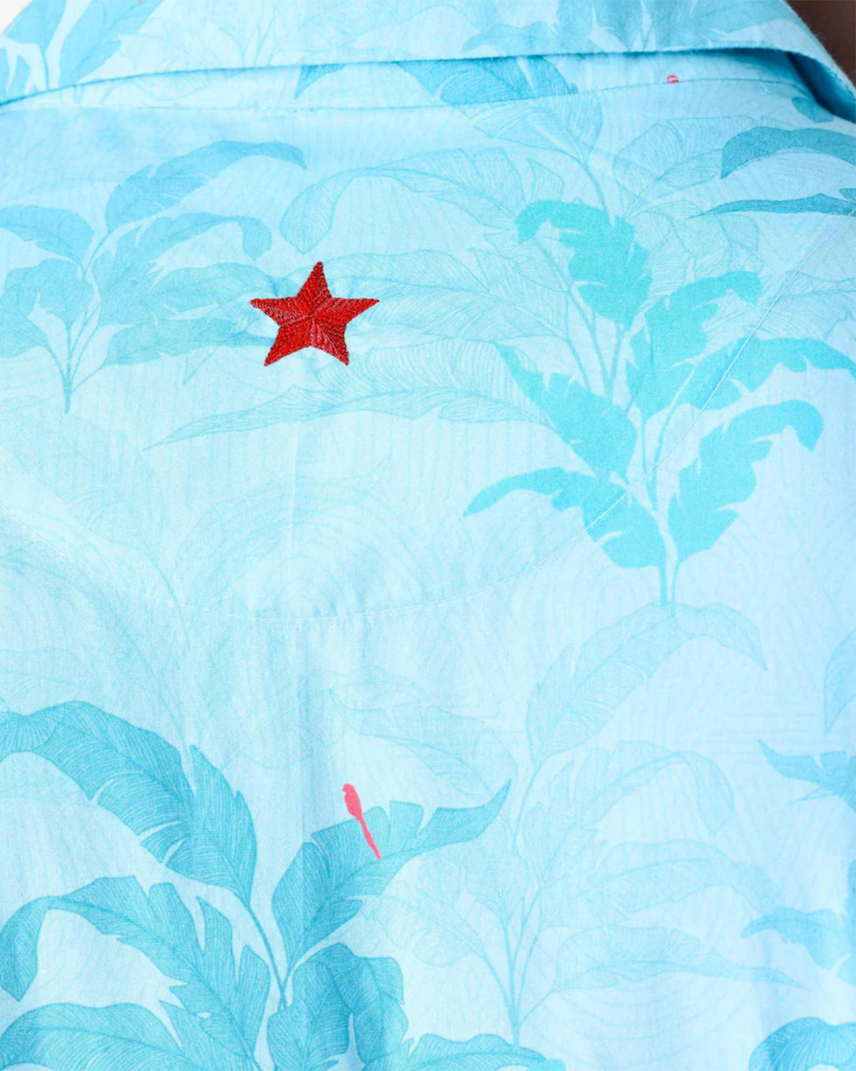 Close-up of a light blue Bouquet Kurta showing leaf print and red bird motifs.