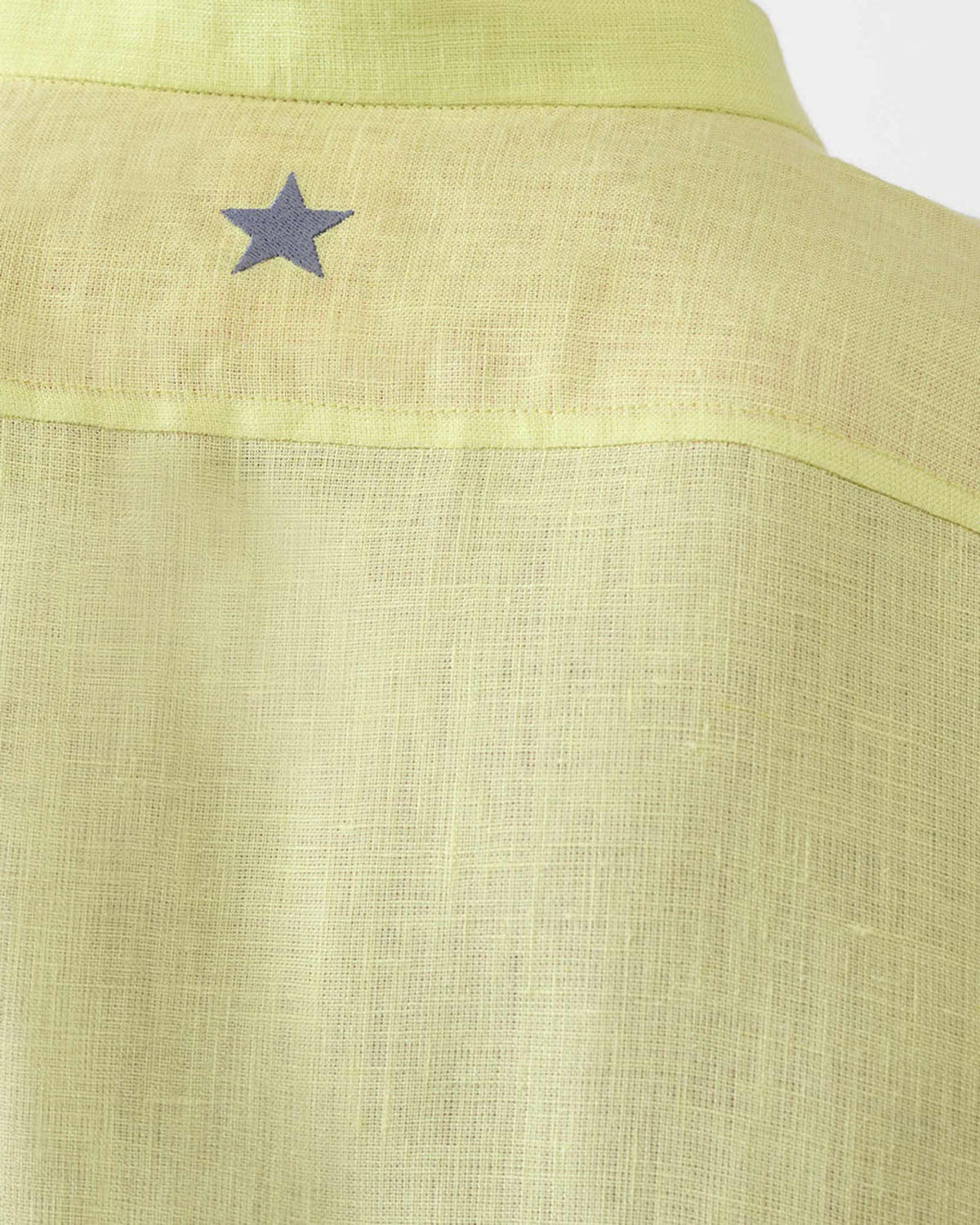 Close-up of a light green Fort kurta back collar with a small blue star.