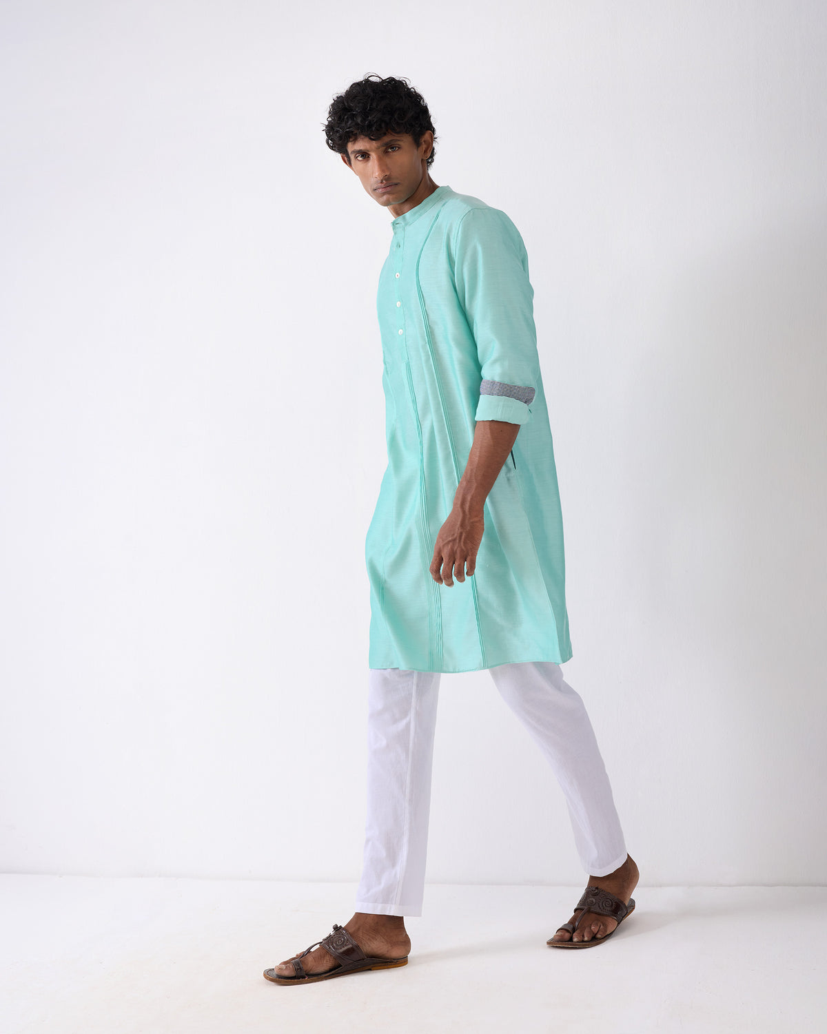 Side view of an aqua Naaz kurta with rolled sleeves.