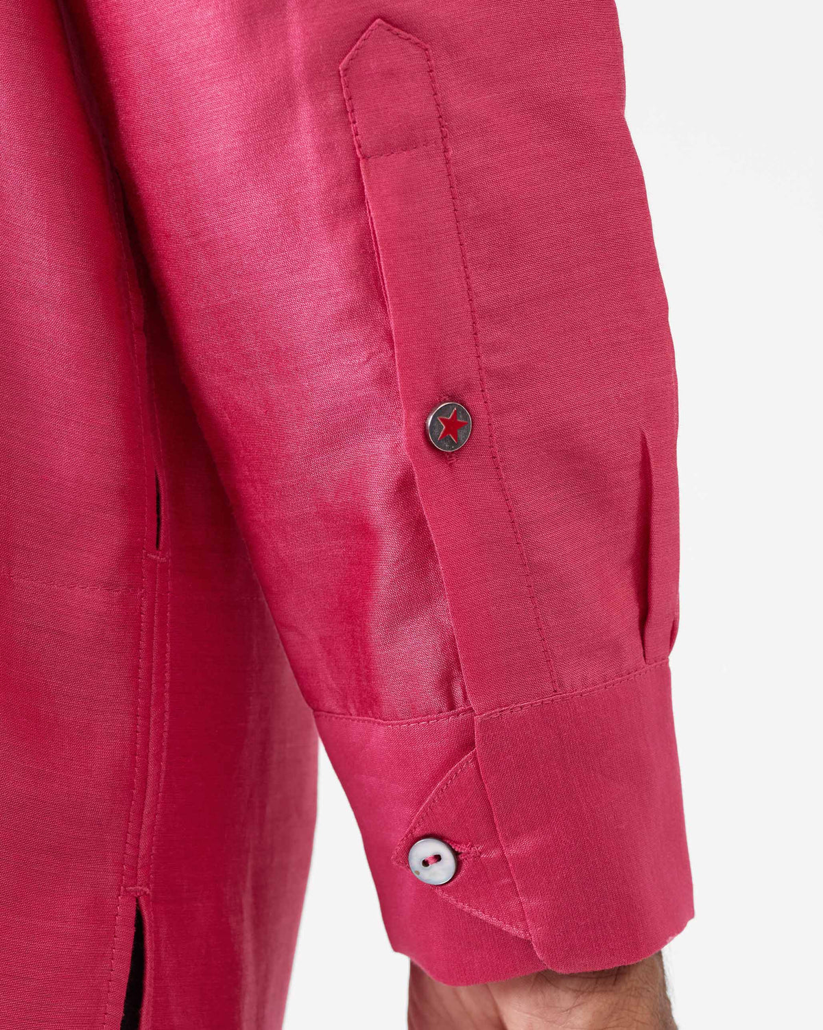 Close-up of a red star cuff button on a watermelon Naaz kurta.