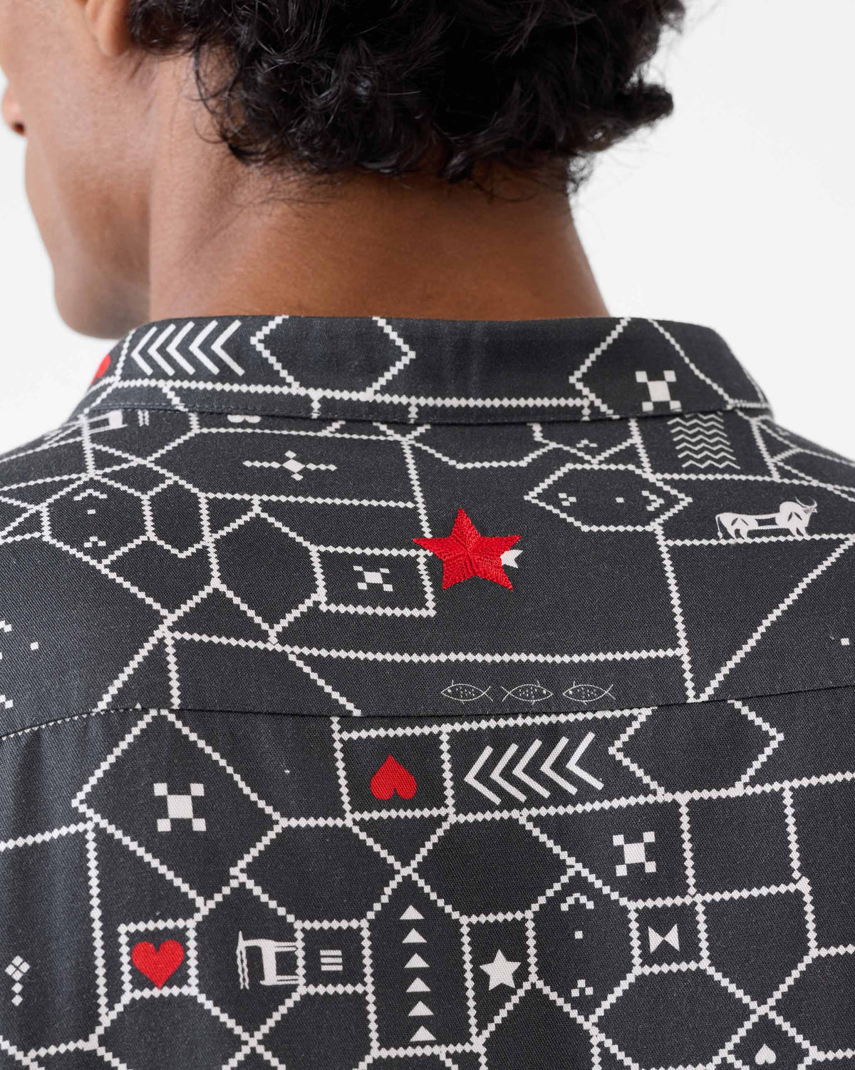 Close-up of a red star on the back of a black and grey Galle Kurta.
