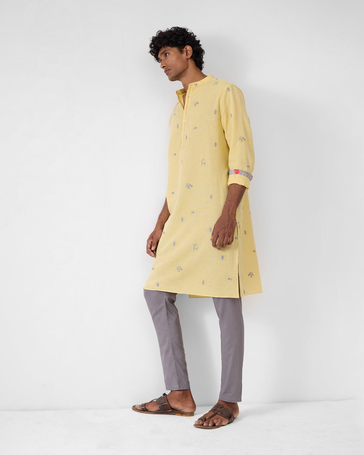 Person wearing a light yellow Astral kurta with grey embroidered motifs.