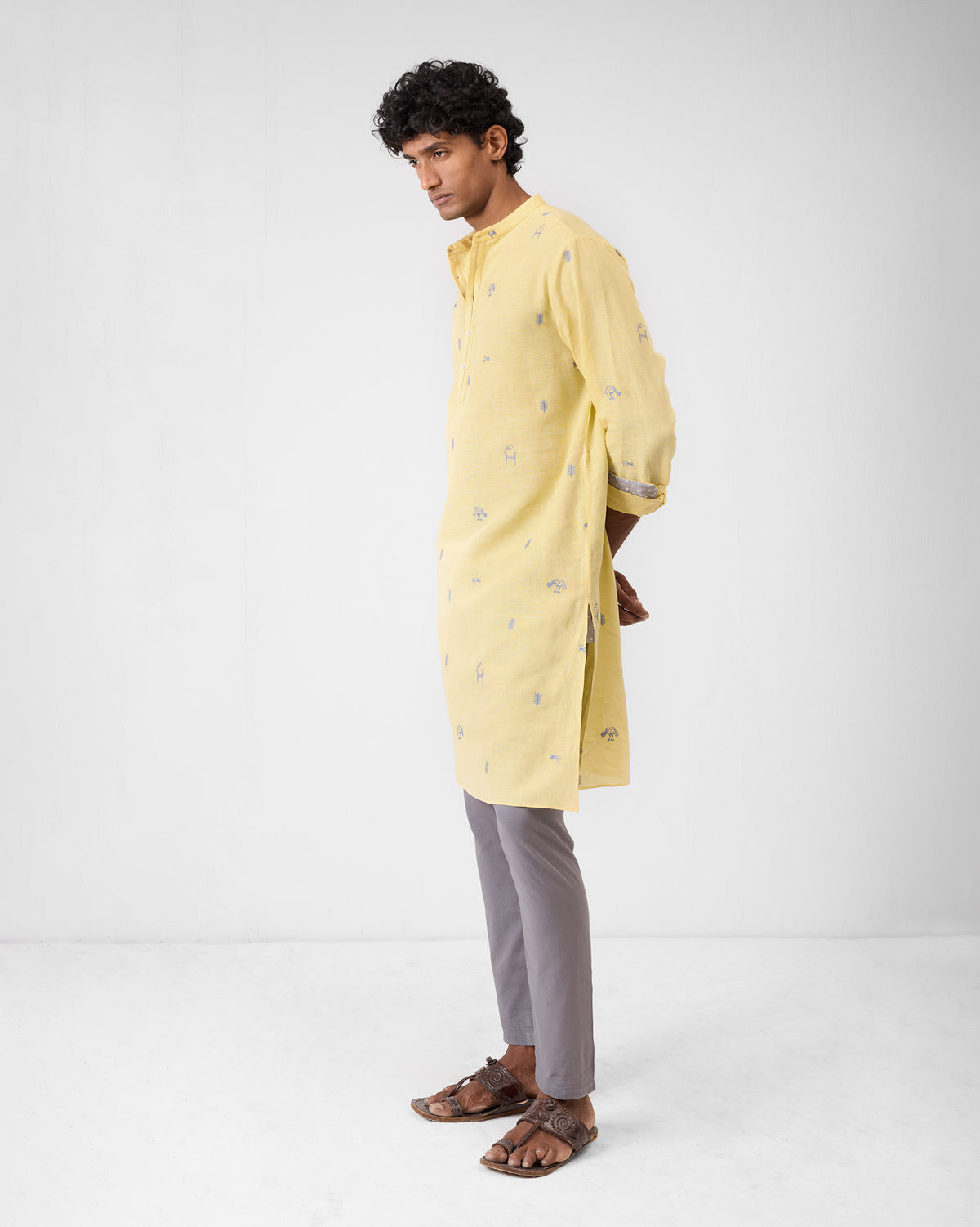 Side view of a light yellow Astral kurta with grey embroidery.