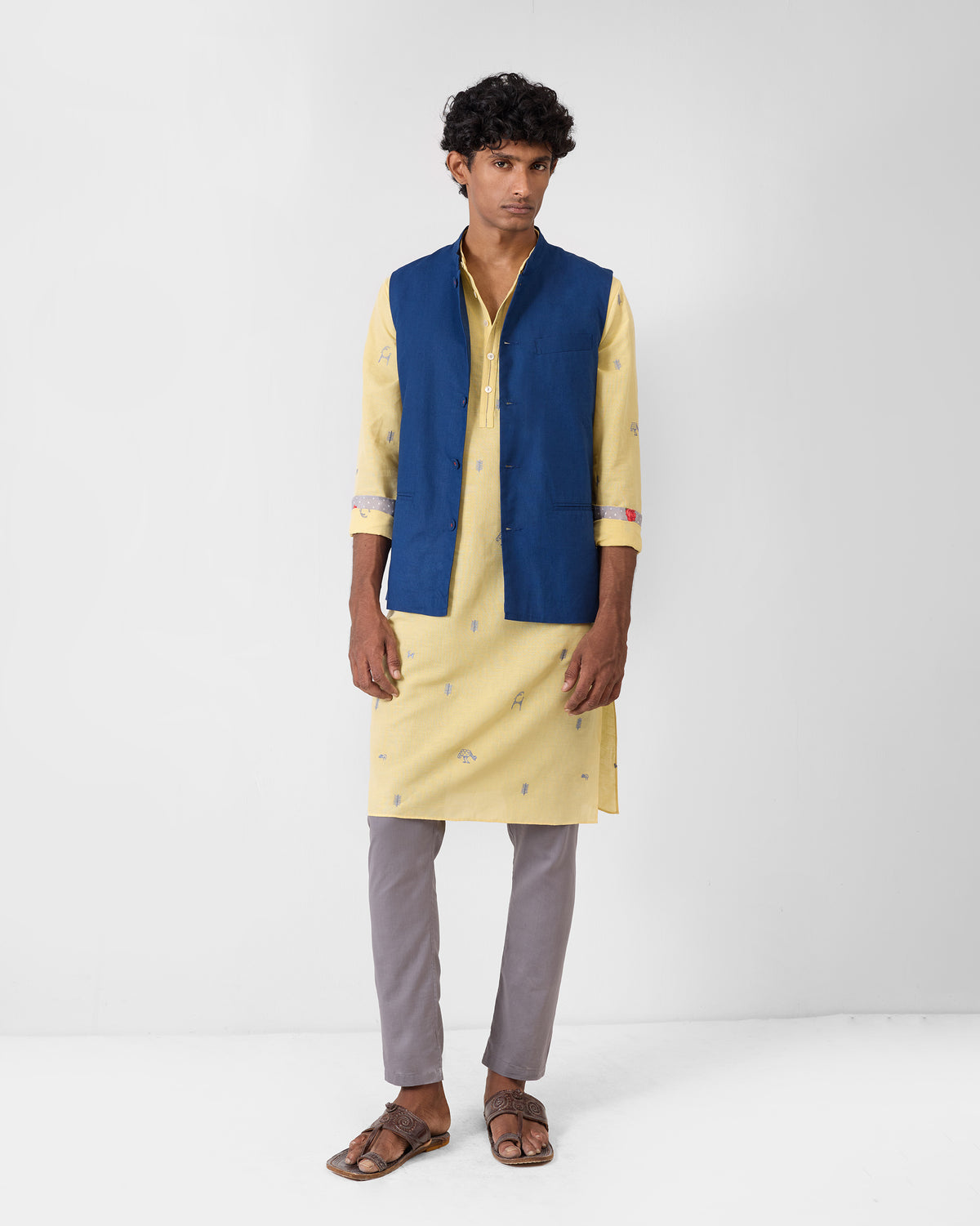 Person wearing a light yellow Astral kurta under a navy jacket.