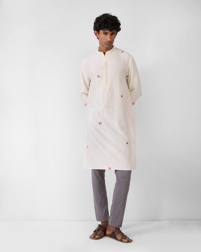 Person wearing an ivory embroidered neckband kurta with red motifs.