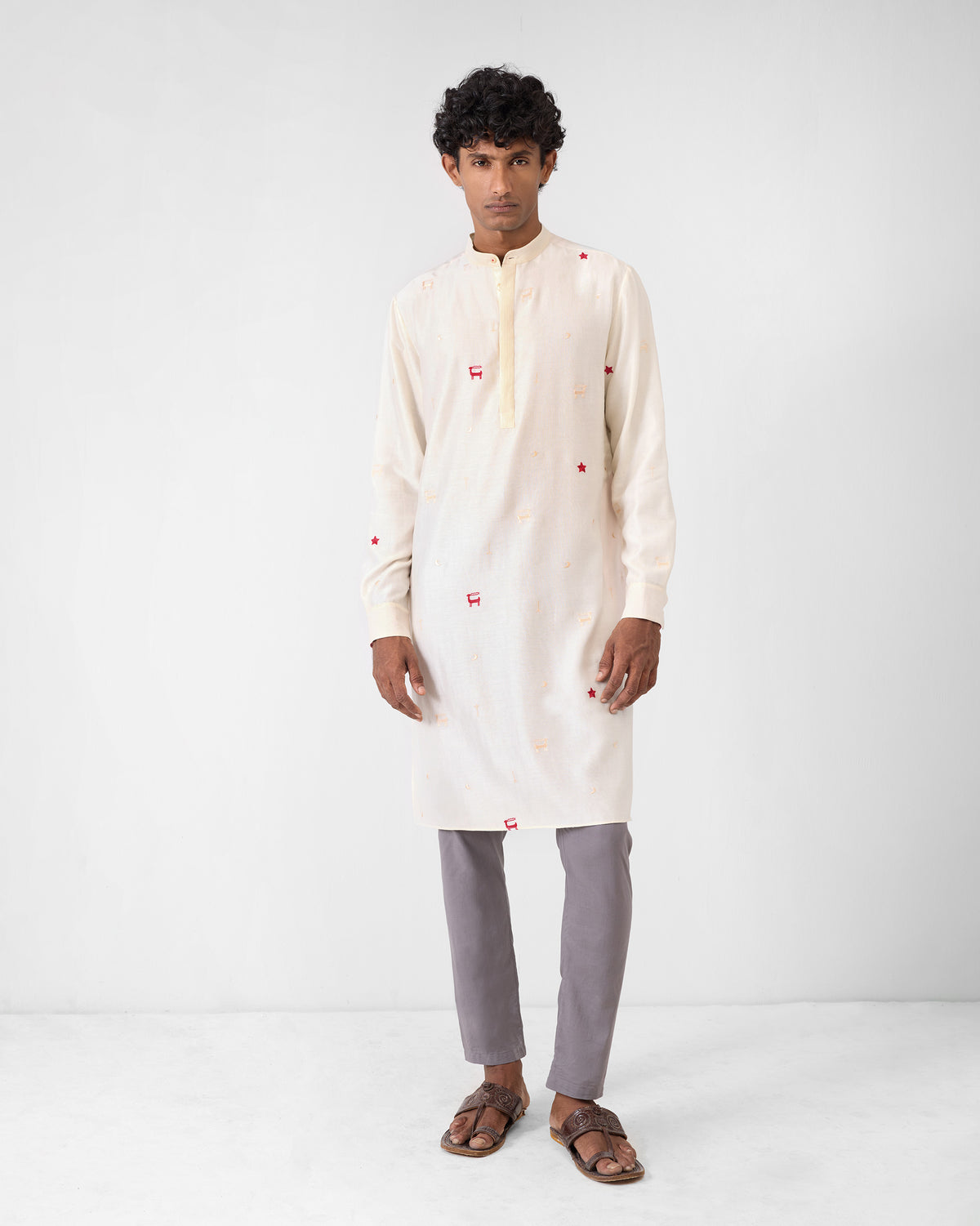Person wearing an ivory neckband kurta with scattered red embroidery.