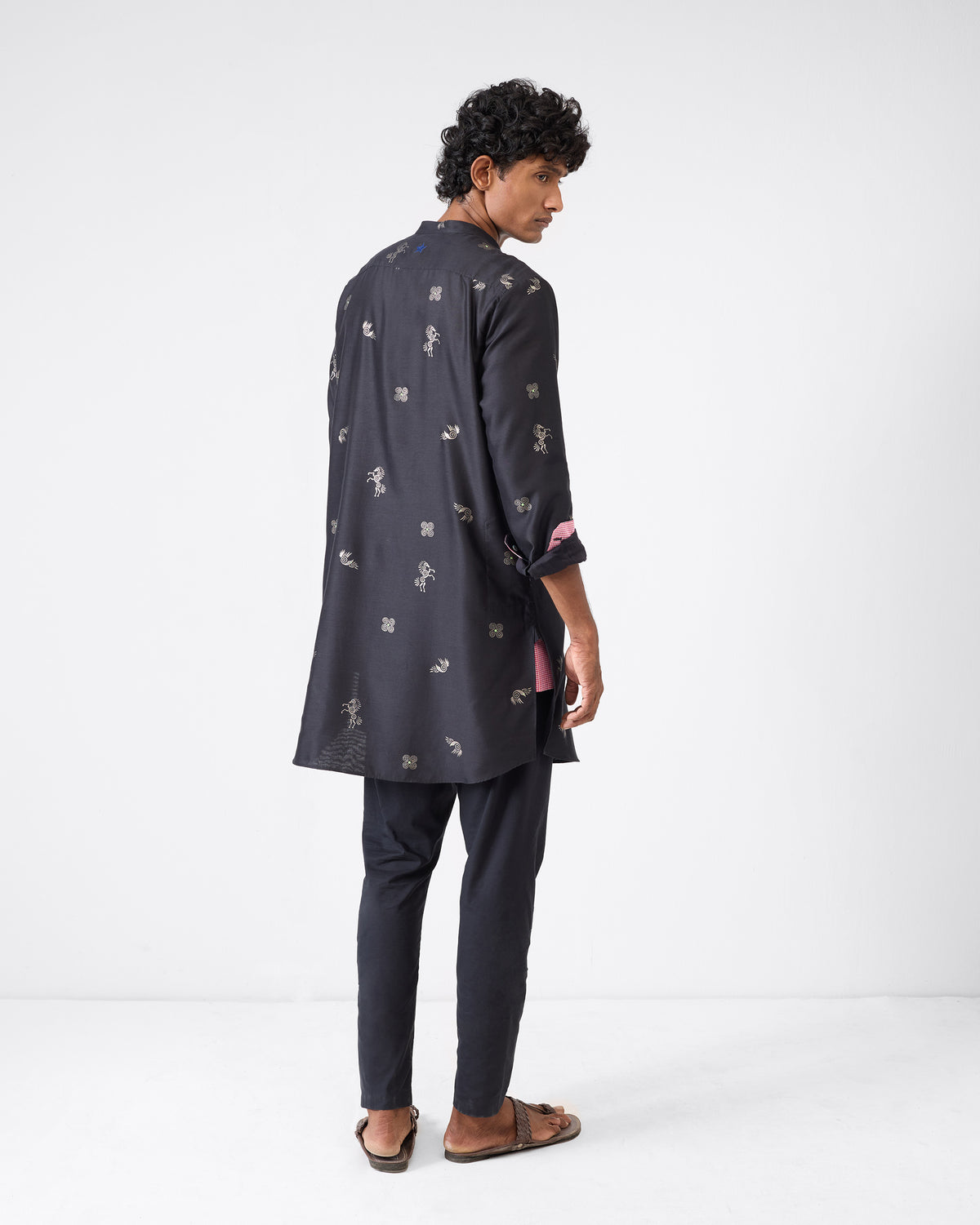 Back of a black Fort Kurta with silver foil print and pink cuff lining.