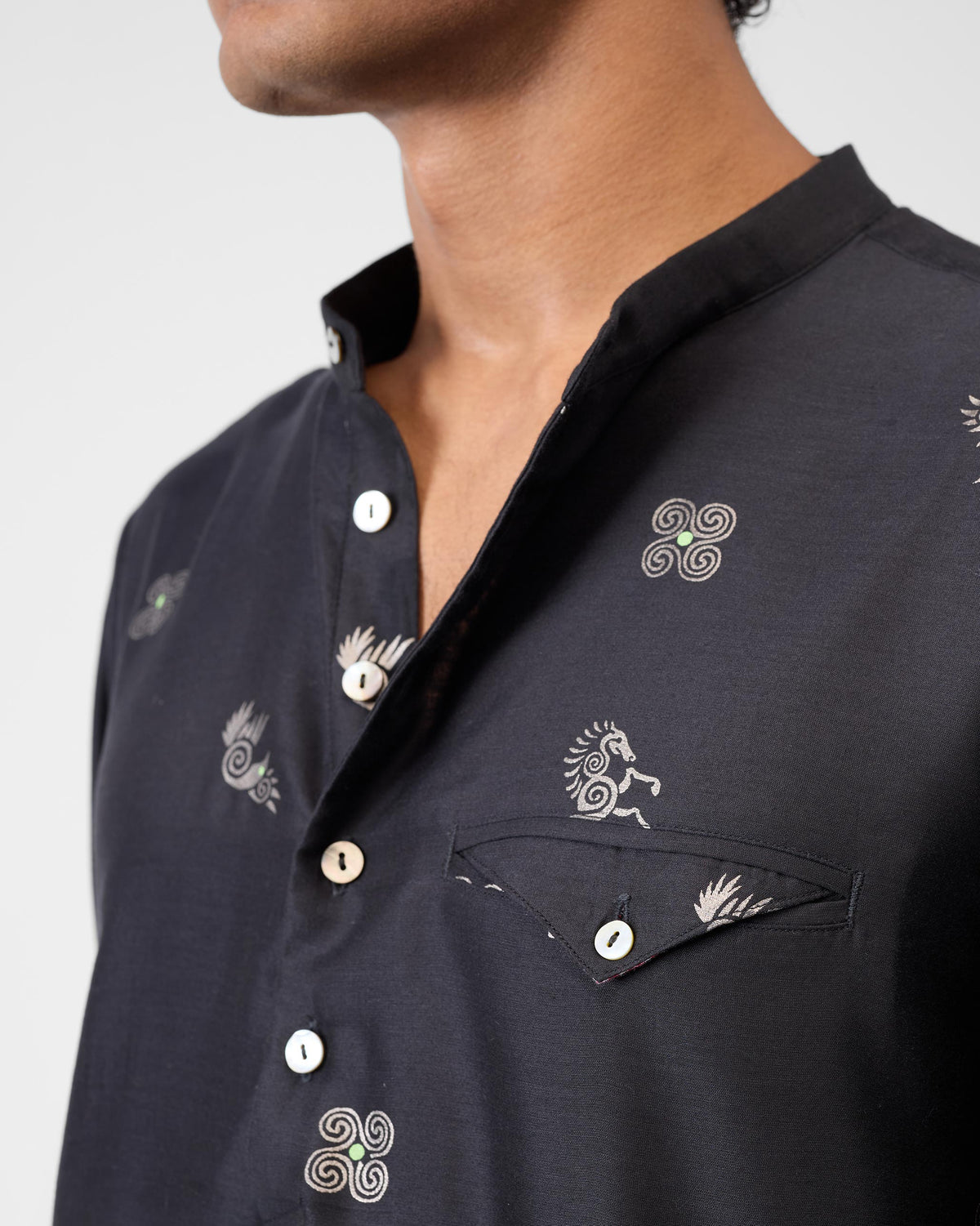 Close-up of a black Fort Kurta showing silver horse foil print and band collar.