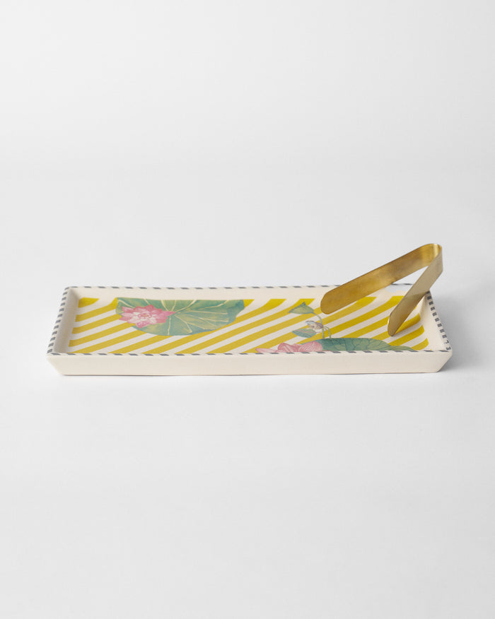 Yellow Lotus Garden cookie tray with pink lotuses and brass tongs.
