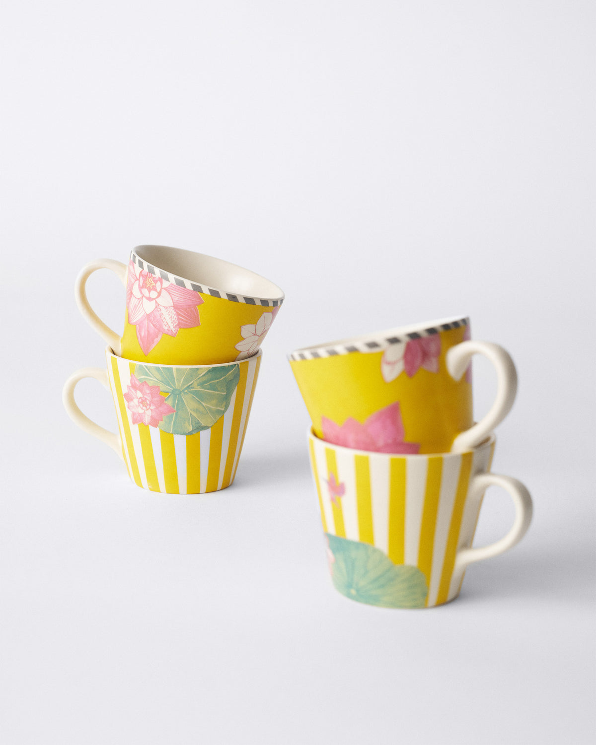 Four Lotus Garden espresso mugs stacked in floral and striped pairs.