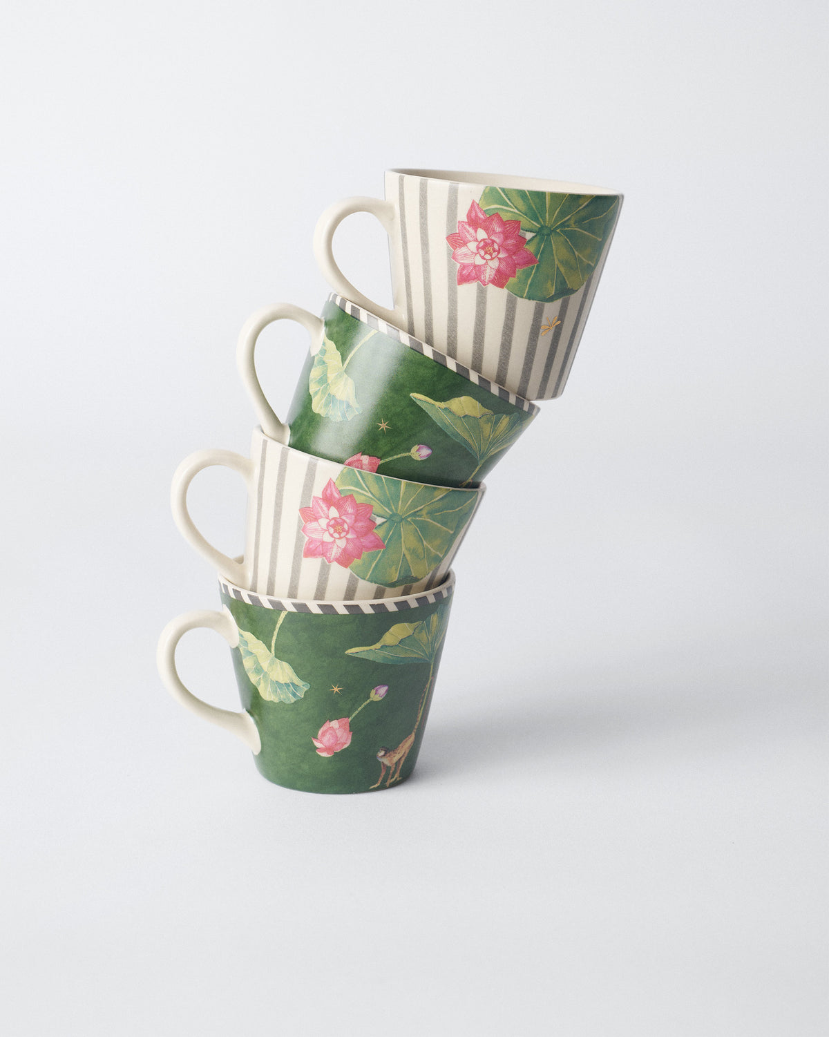 Stack of four Float espresso mugs with lotus and monkey motifs.