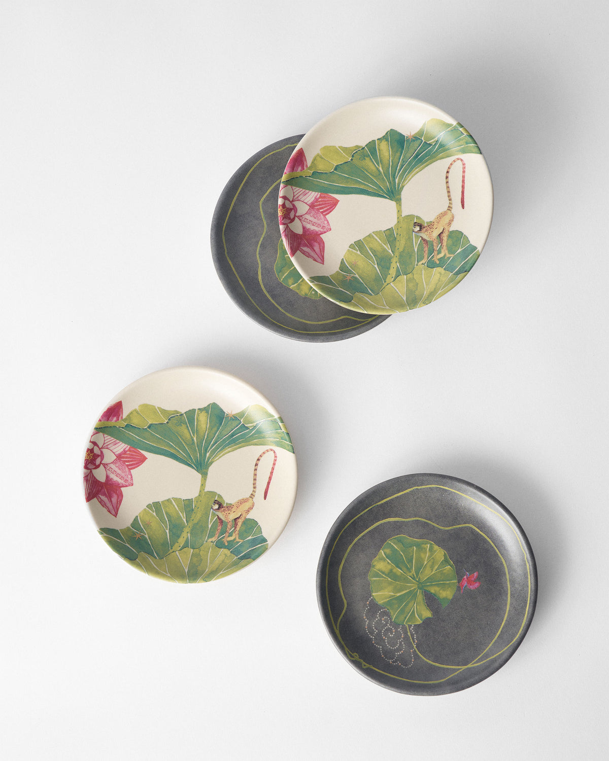 Float tea plates in cream monkey print and charcoal lily pad designs.
