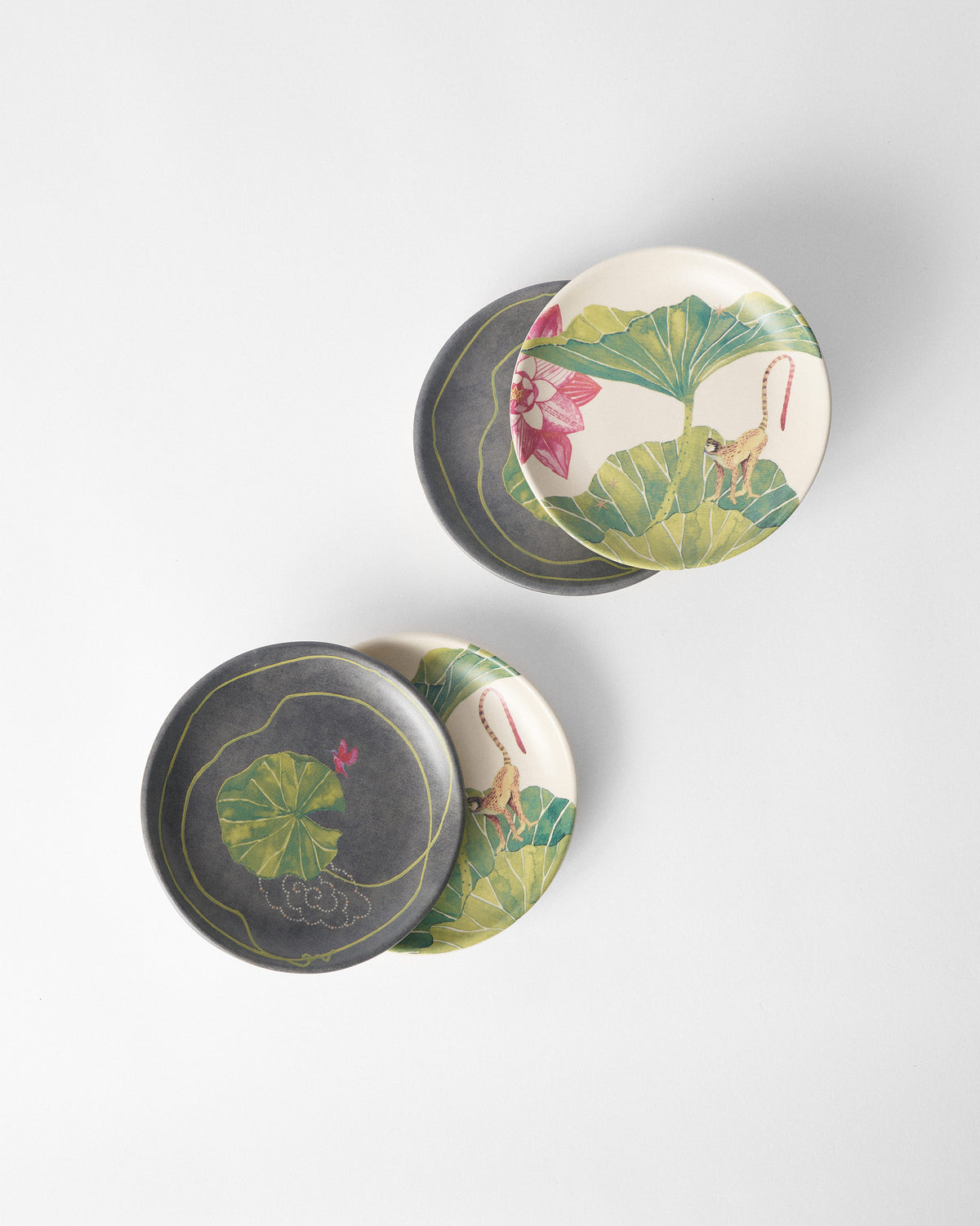 Paired Float tea plates stacking cream monkey and charcoal lily pad prints.