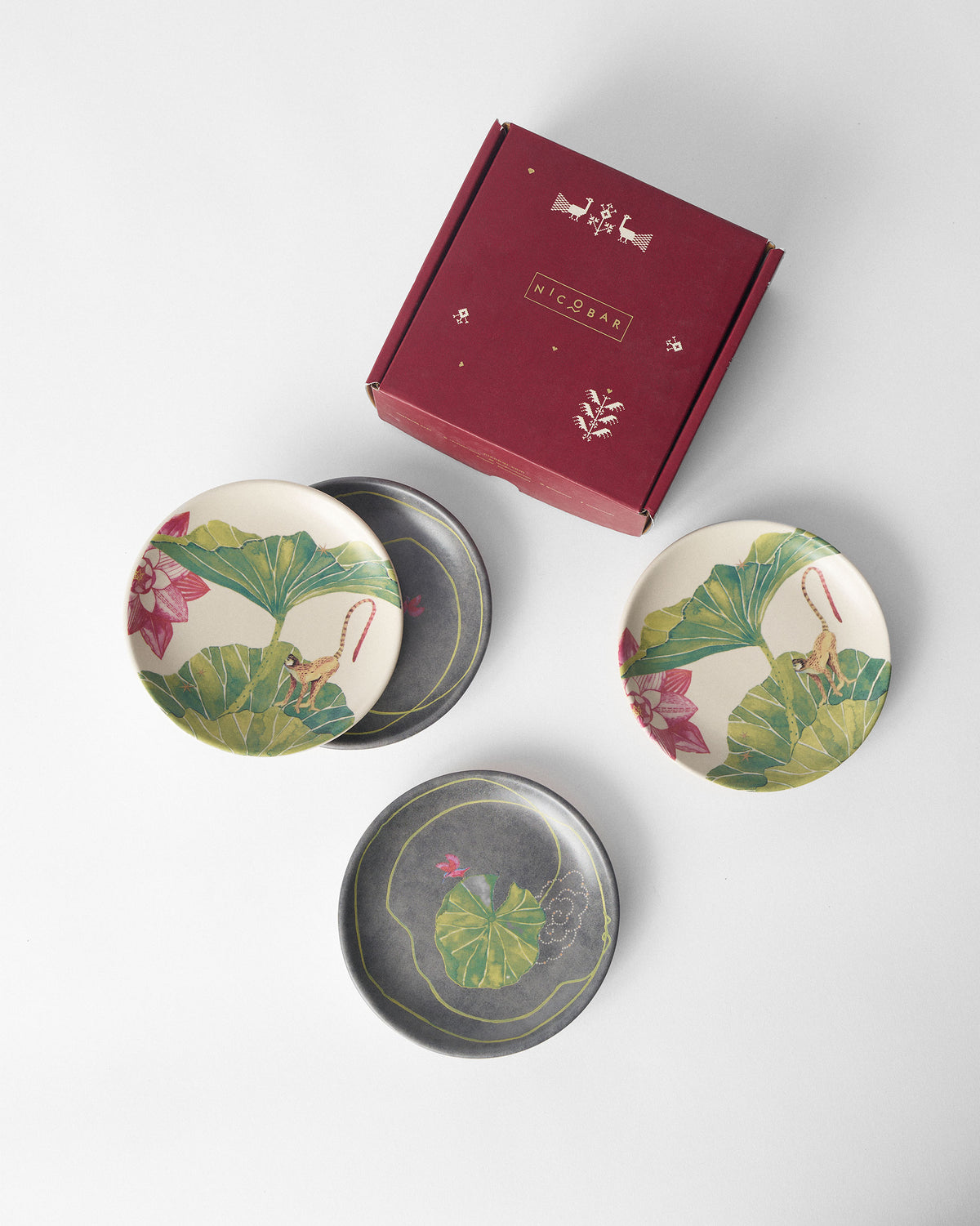 Float tea plate set of four with a maroon Nicobar gift box.