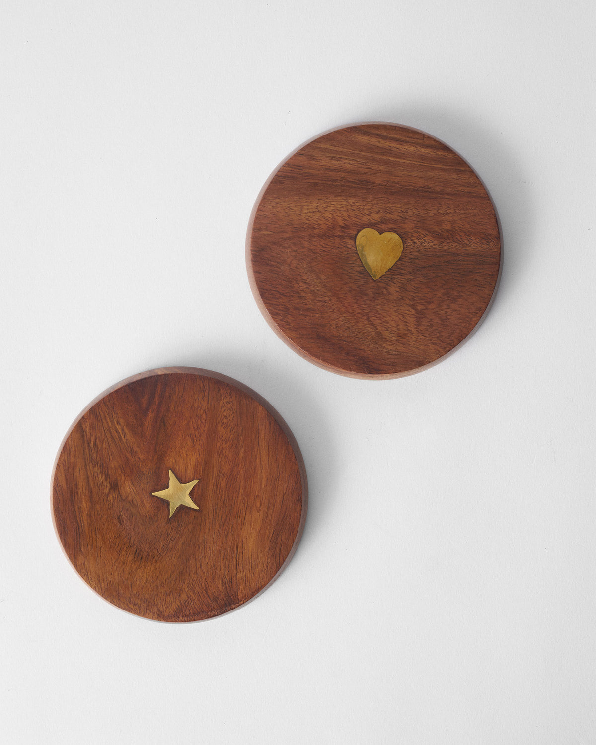 Wooden Aster lids laid flat showing brass heart and star inlays.
