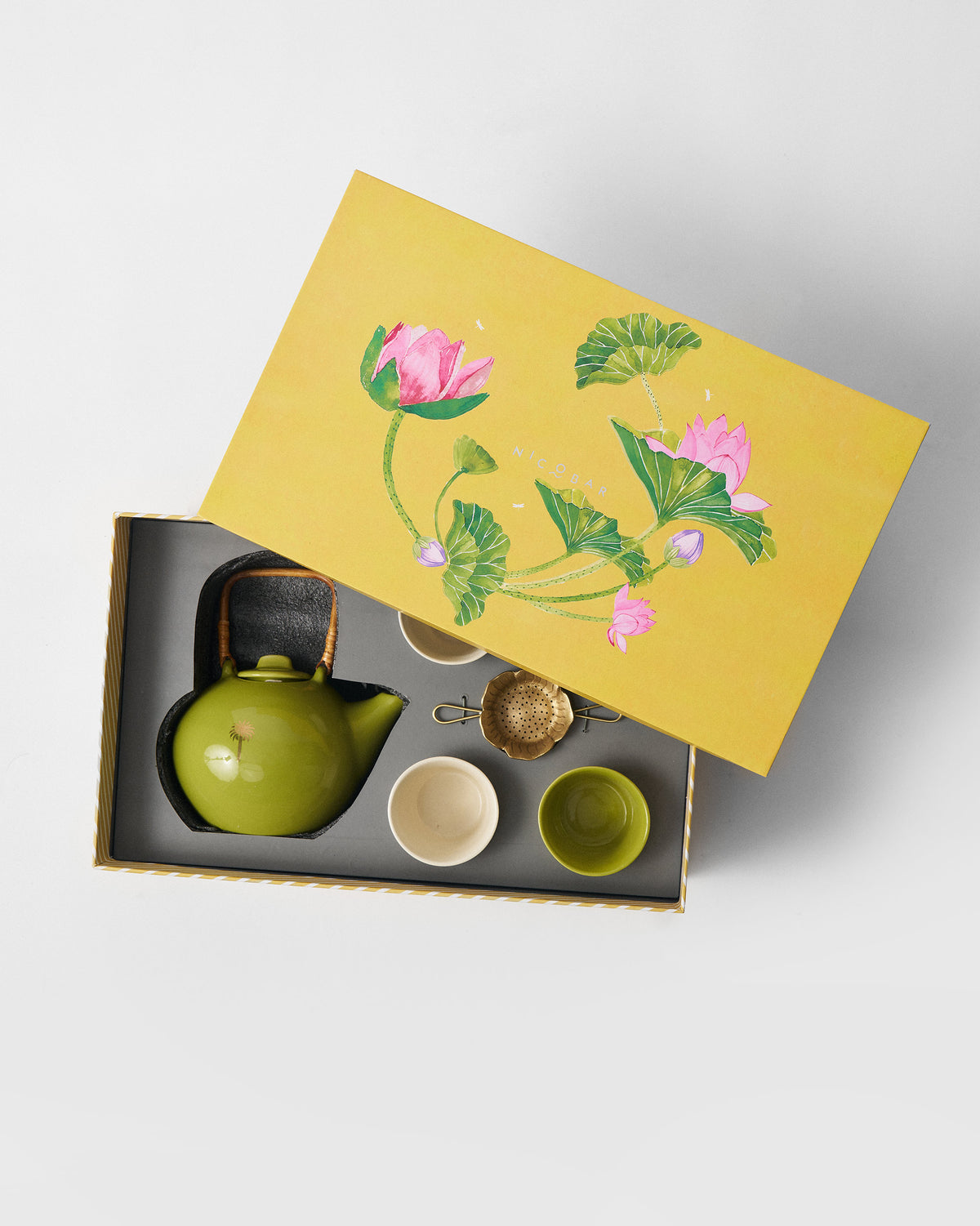 Float Tea Set in packaging beside a yellow lotus gift box lid.