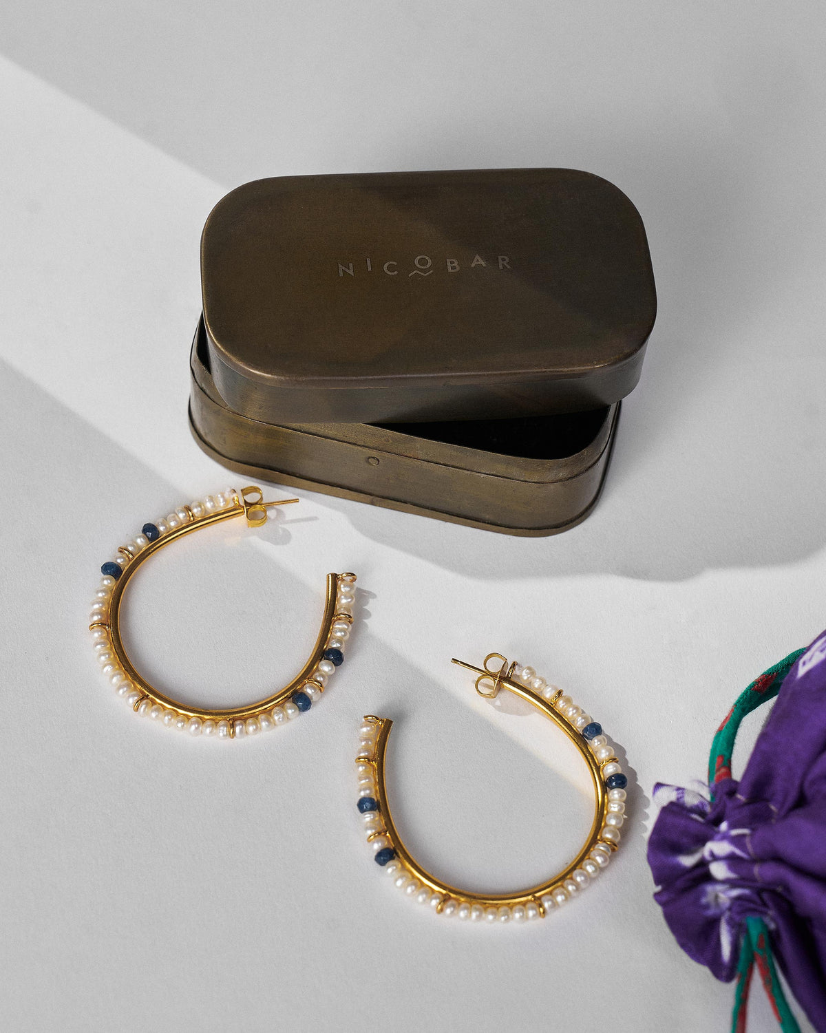 Large gold Raja pearl balis beside a Nicobar gift box.
