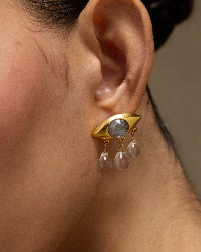 Side profile of a gold Noor eye earring with labradorite and quartz drops.