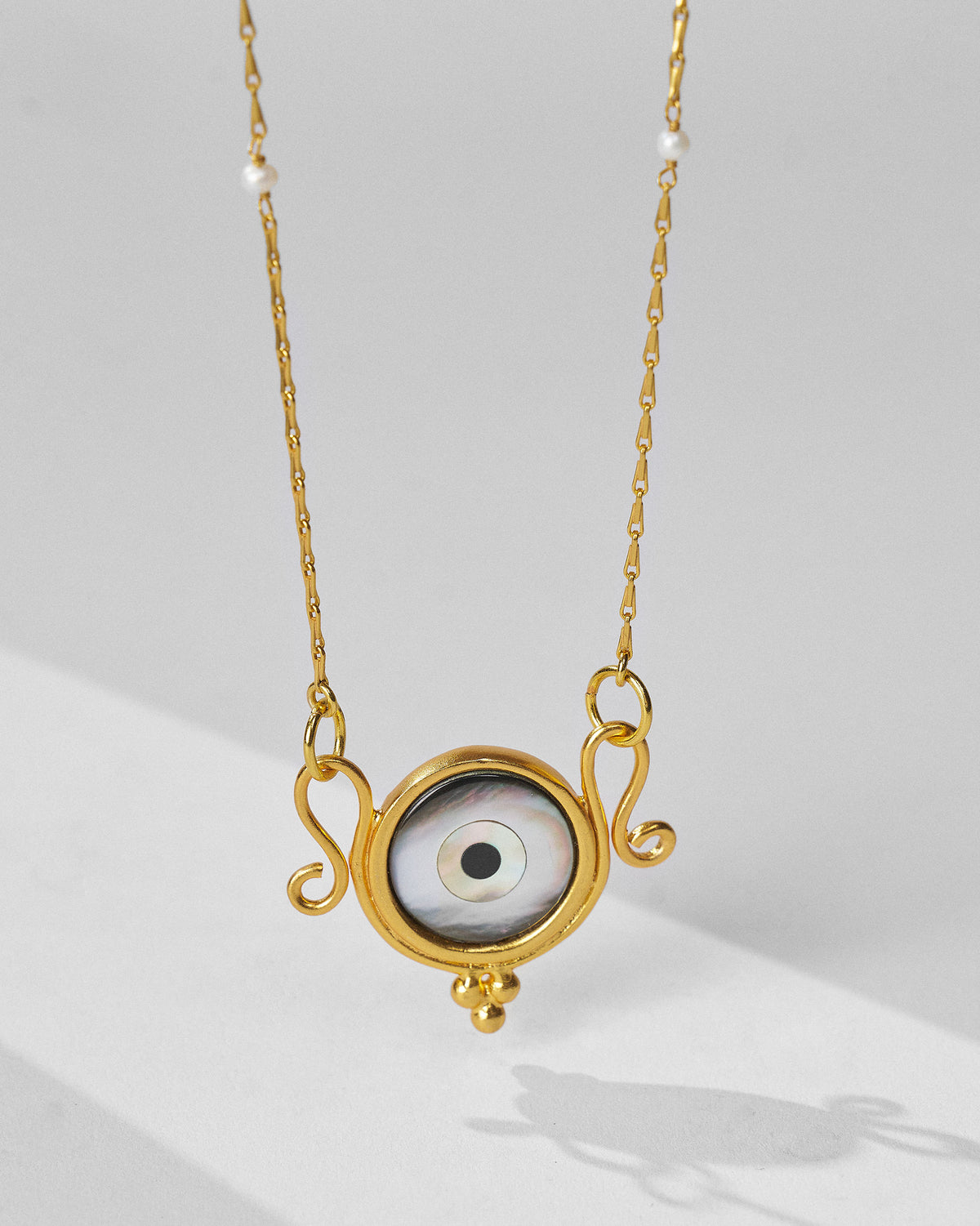 Gold Turki Nazar chain hanging to show the eye pendant and pearls.