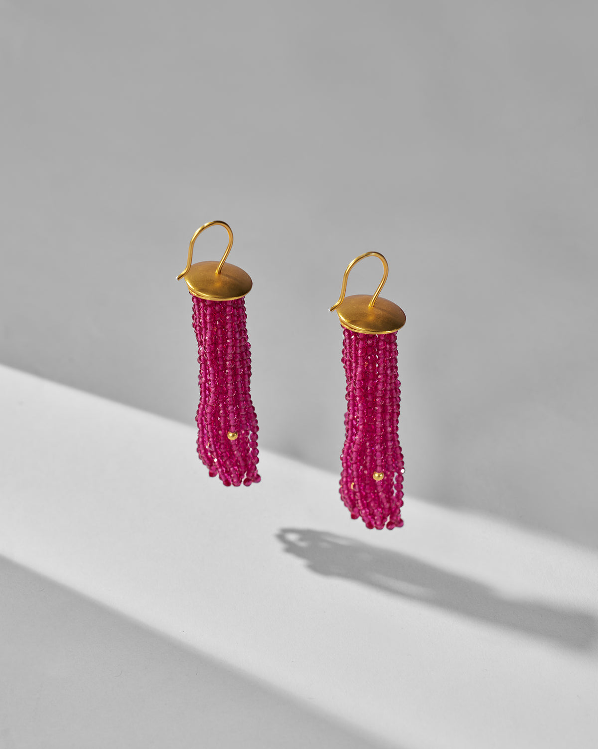Pair of magenta Glass Tassel earrings with faceted beads and gold caps.