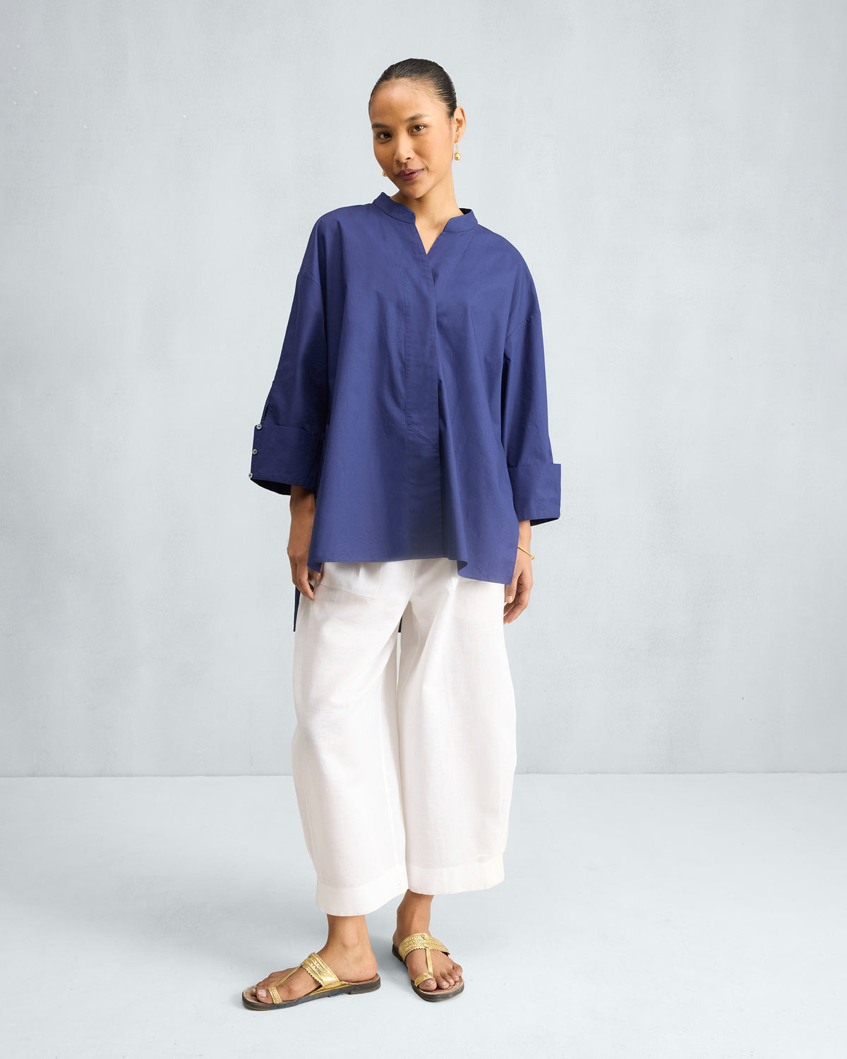 Person wearing an ink blue Cirrus Shirt with rolled cuffs.