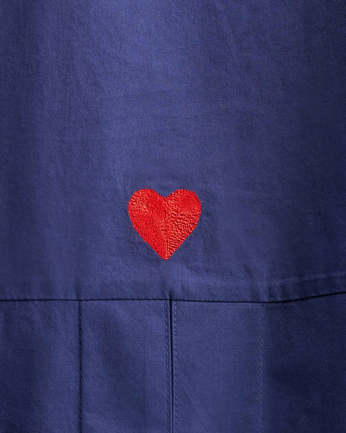 Close-up of a red heart embroidered on the Cirrus Shirt back hem.