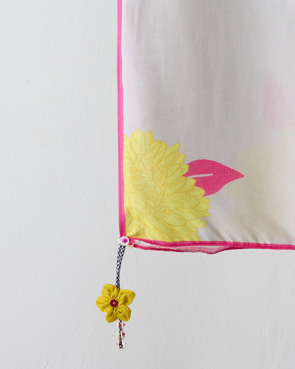 Close-up of a grey Floral Scarf corner showing a yellow bloom and pink leaf.