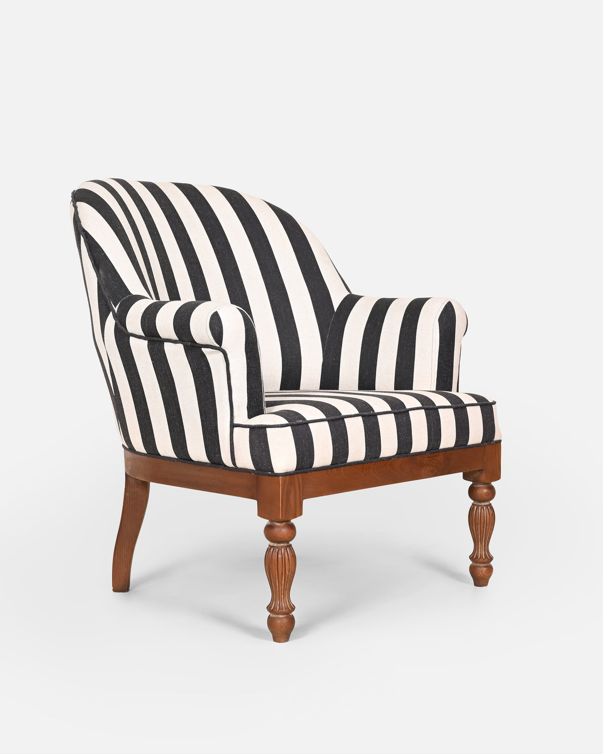 Angled side view of Cove Arm Chair in black and cream stripes on turned wooden legs.
