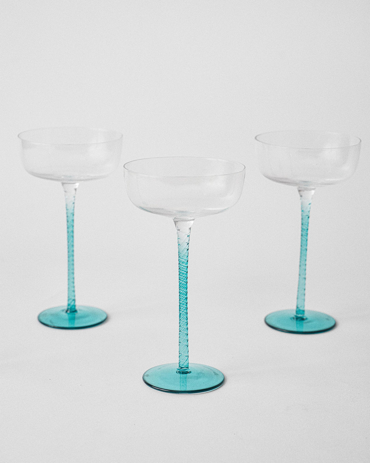 Three Lumen cocktail glasses showing textured teal stems and bases.