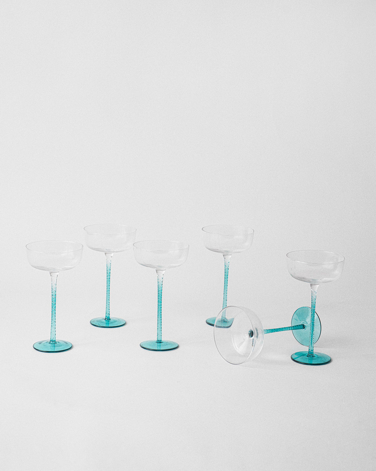 Lumen cocktail glass set with one glass tipped to show the teal base.