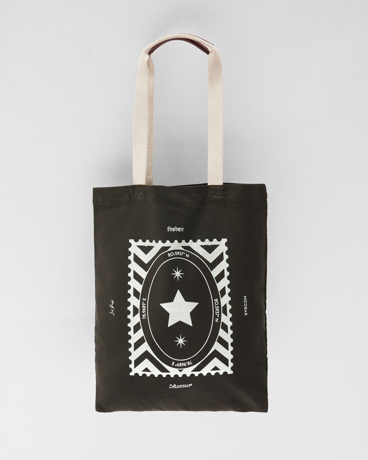 Charcoal Decade Tote with a silver stamp star graphic and cream straps.