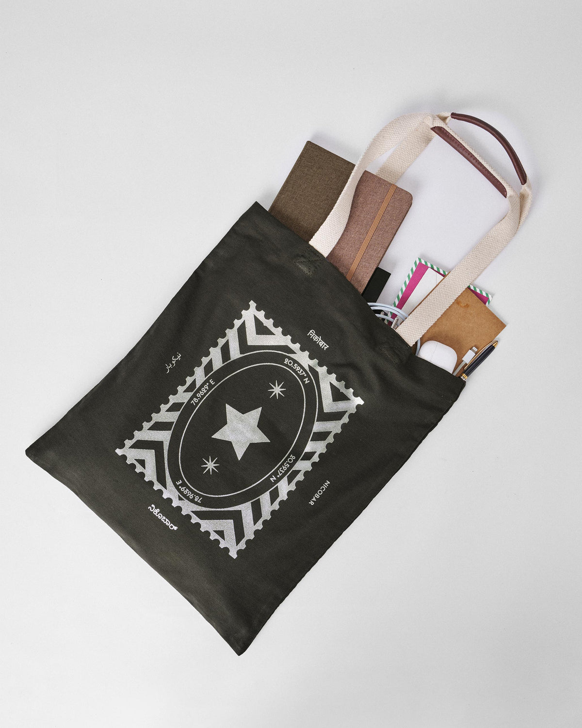 Open charcoal Decade Tote packed with notebooks and everyday essentials.