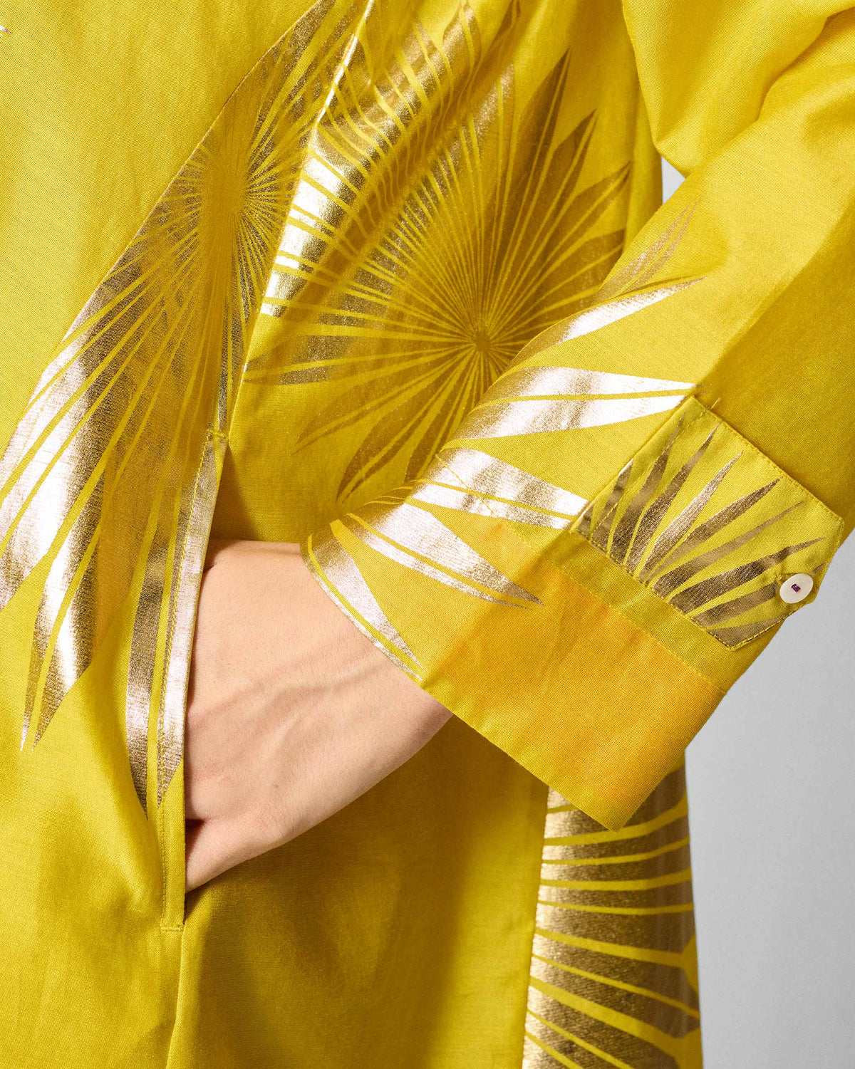 Close-up of a chartreuse Flare Panelled Shirt showing a gold palm print and pocket.