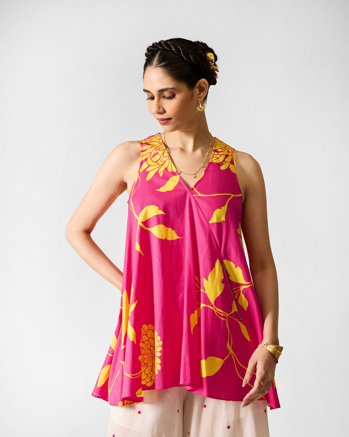 Person wearing a fuchsia lantern top with yellow floral print and a flared silhouette.