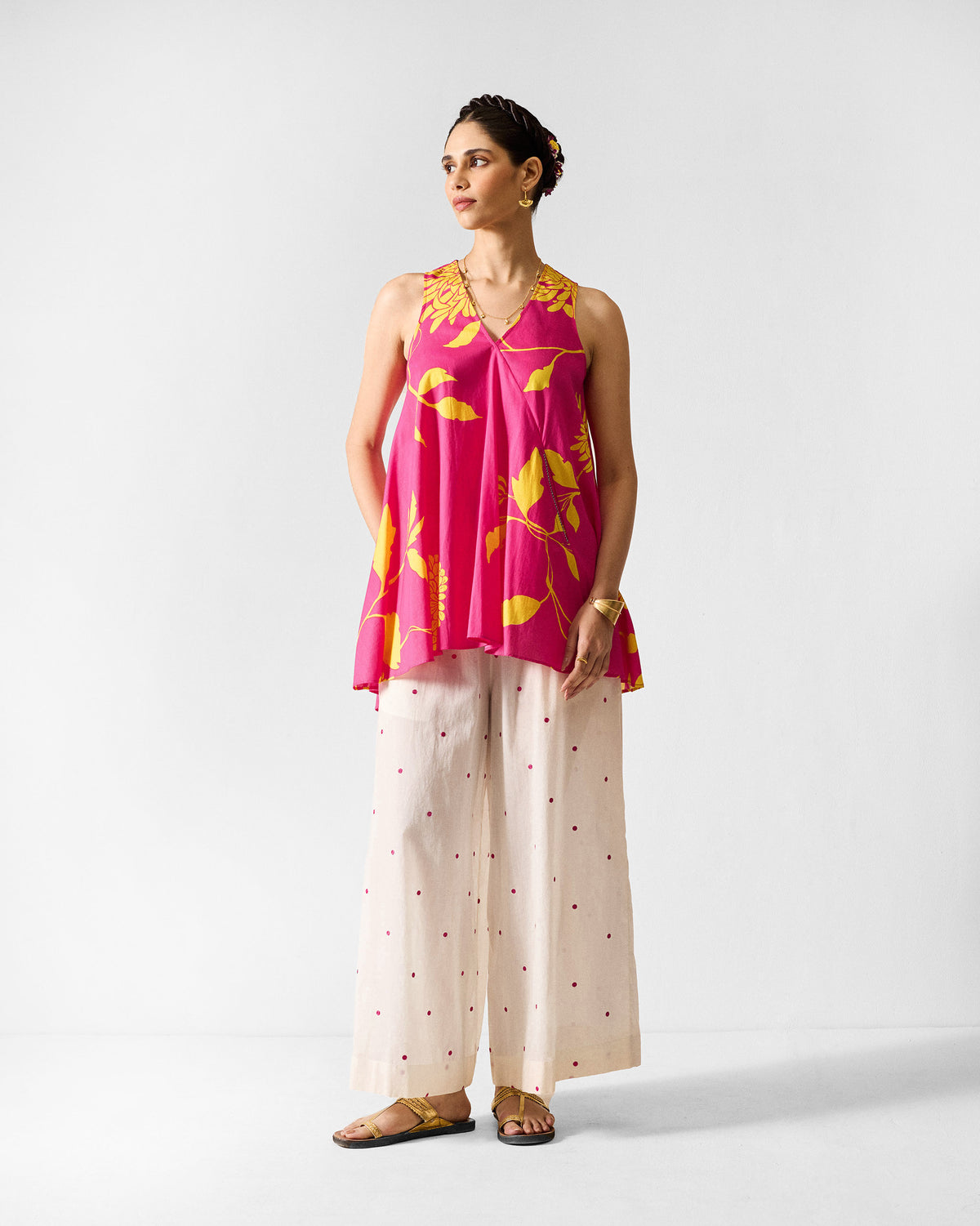 Person wearing a fuchsia and lime printed lantern top to mid-thigh.