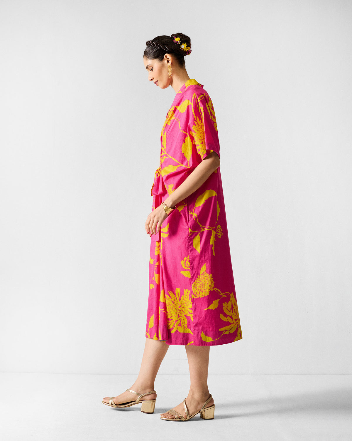 Side view of a fuchsia Doda dress with lime floral print.