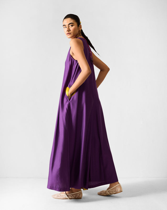 Back of a purple Amreli jumpsuit with lime yellow pocket lining.