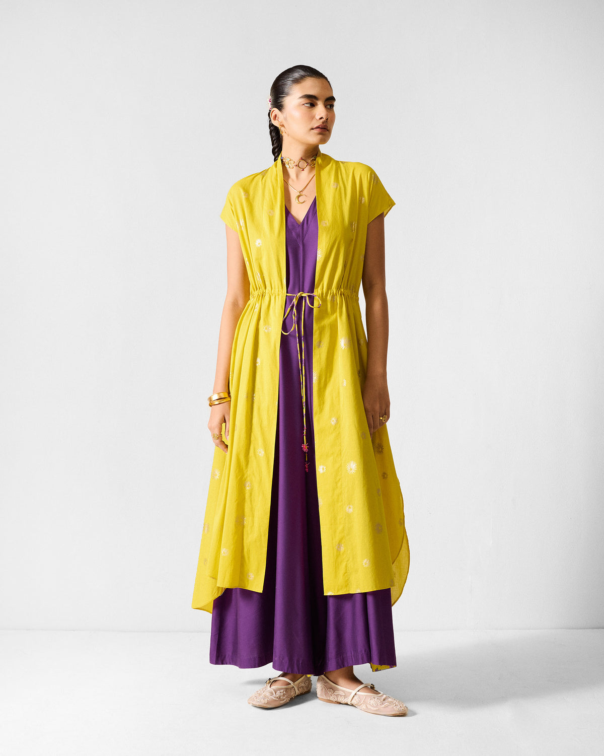 Purple Amreli jumpsuit worn under a lime yellow embroidered overlay.