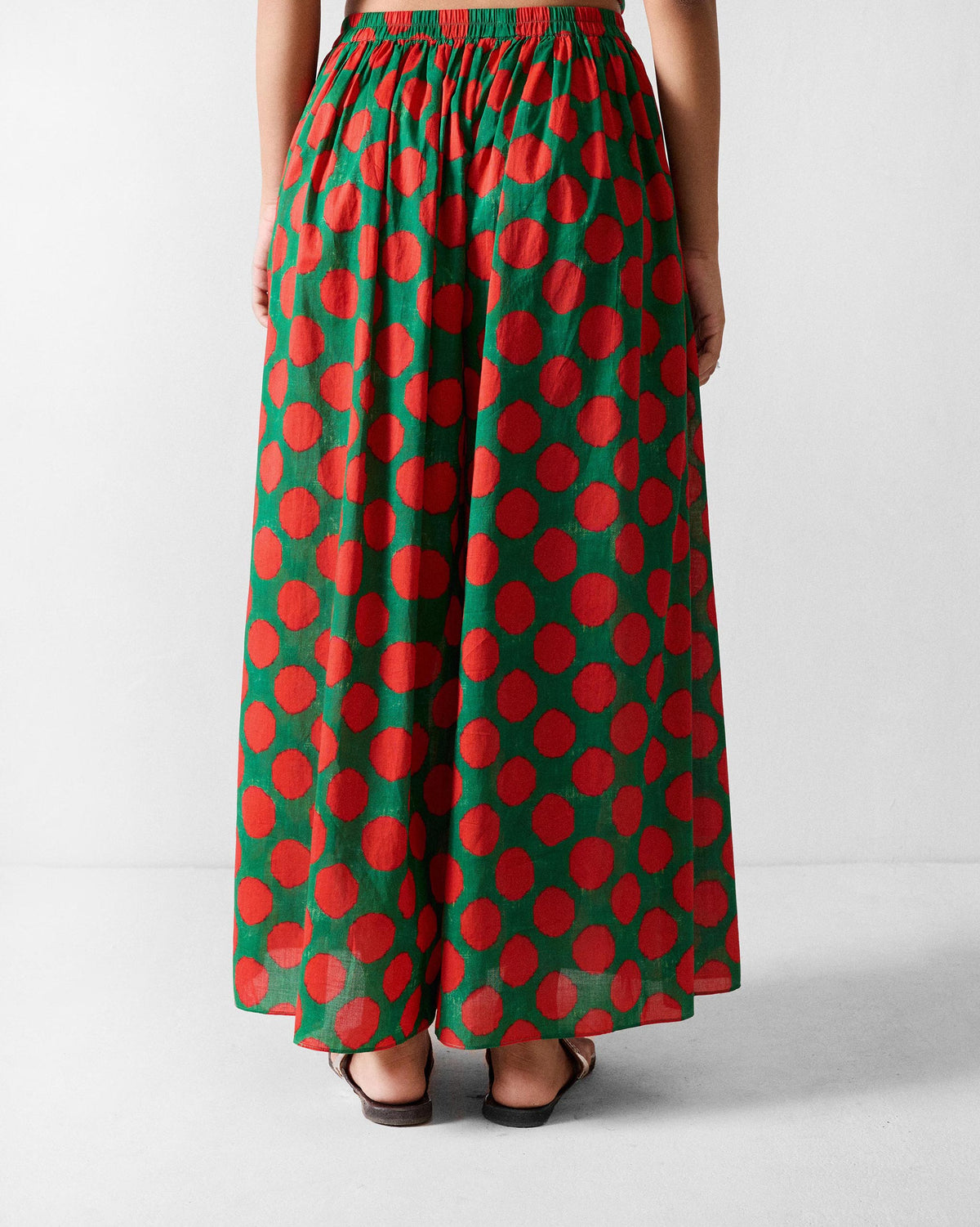 Back of Yoi Hem Pants with a red dot print worn by a person.