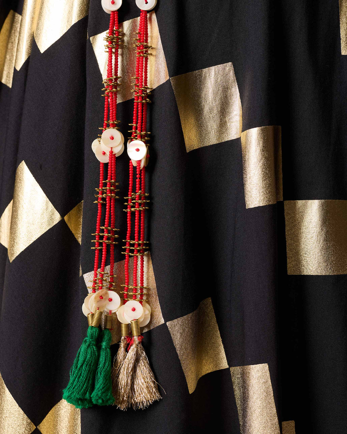 Close-up of an Afsar Skirt showing gold foil squares and beaded tassels.