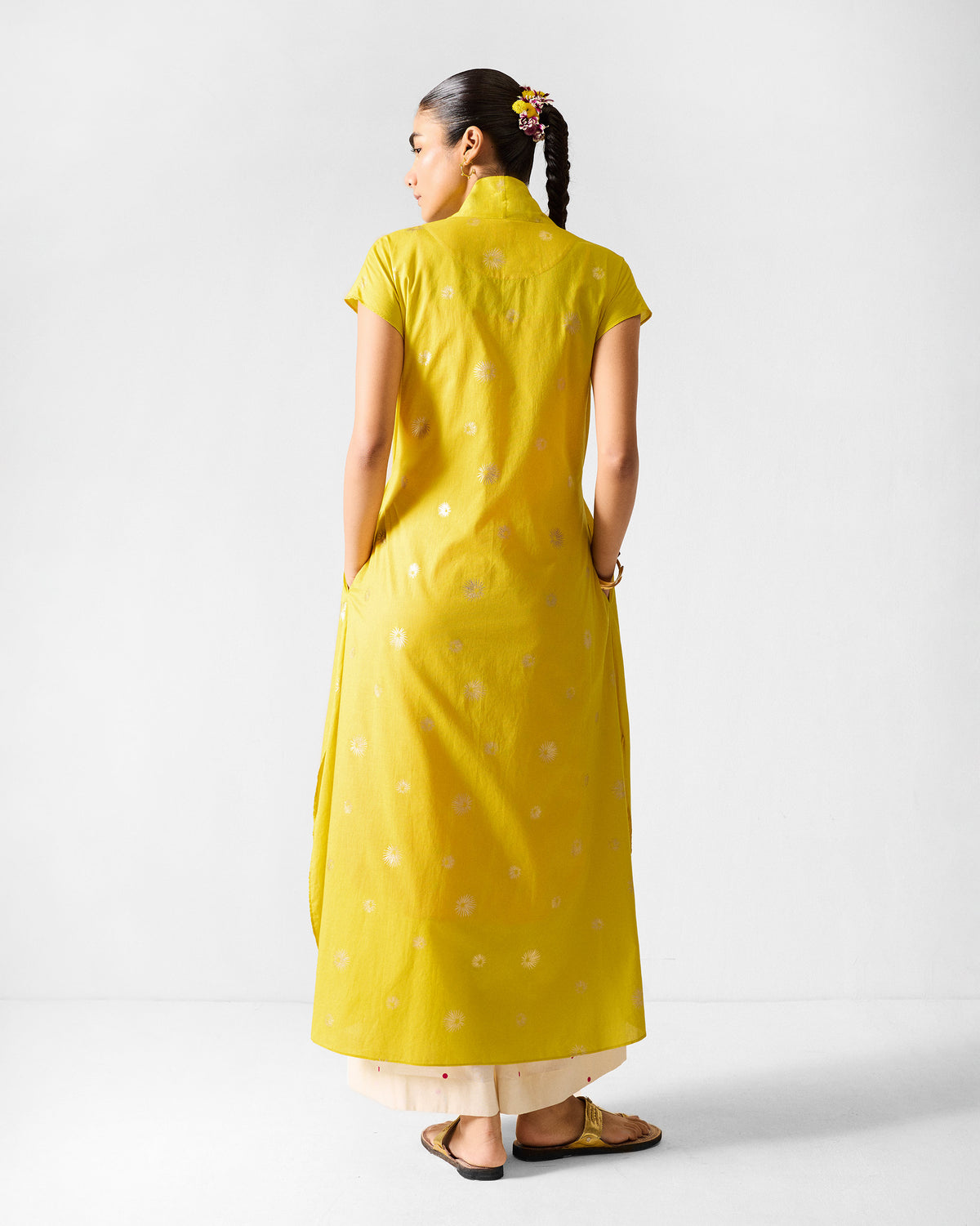 Back of a chartreuse Myra overlay with gold print and side pockets.