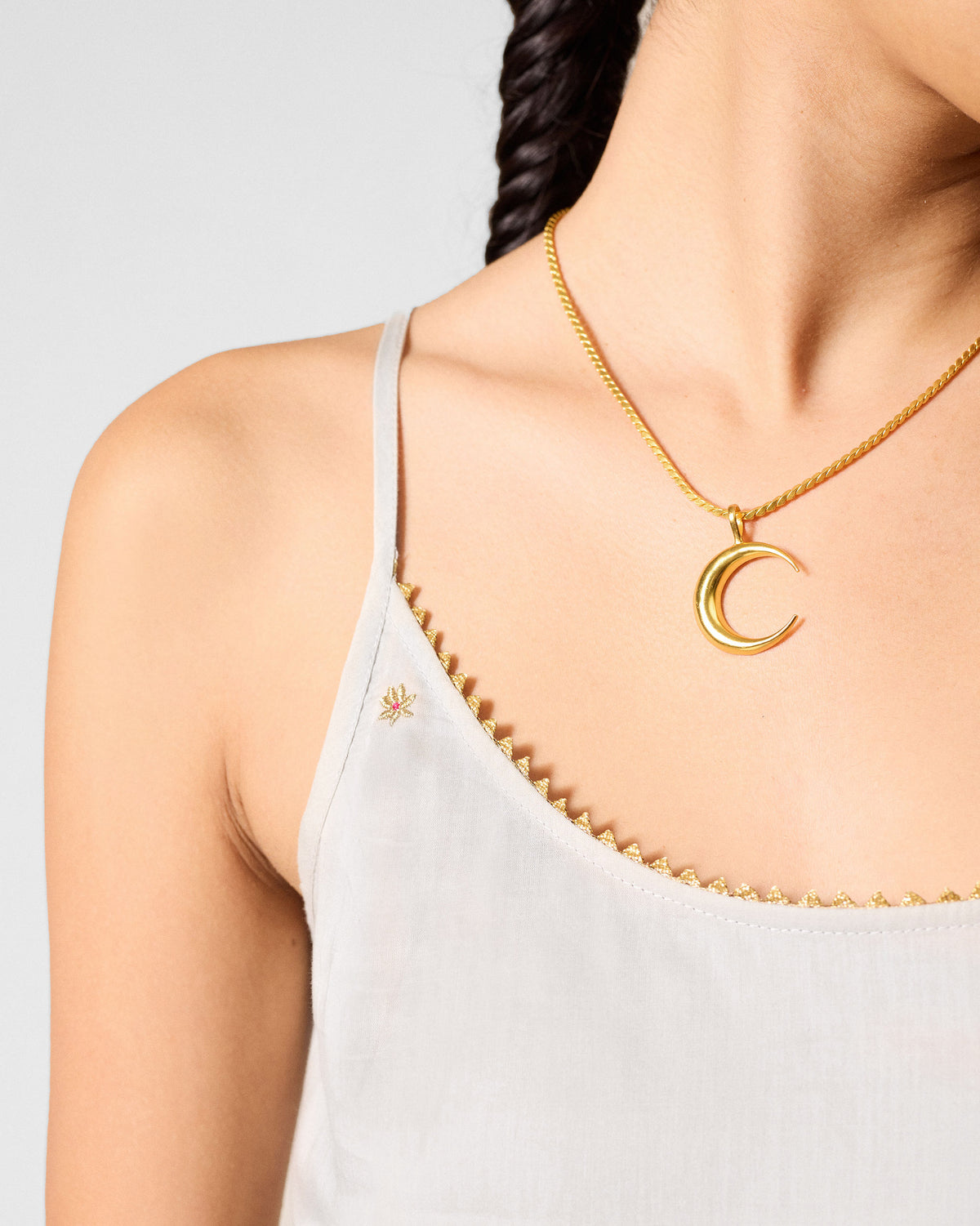 Close-up of a grey Kumaon Slip showing gold scalloped trim along the neckline.