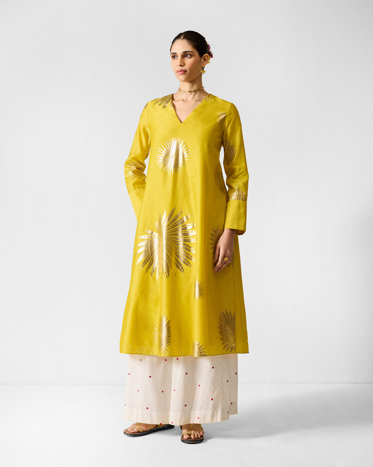 Person wearing a chartreuse gold-printed V-neck flared kurta.