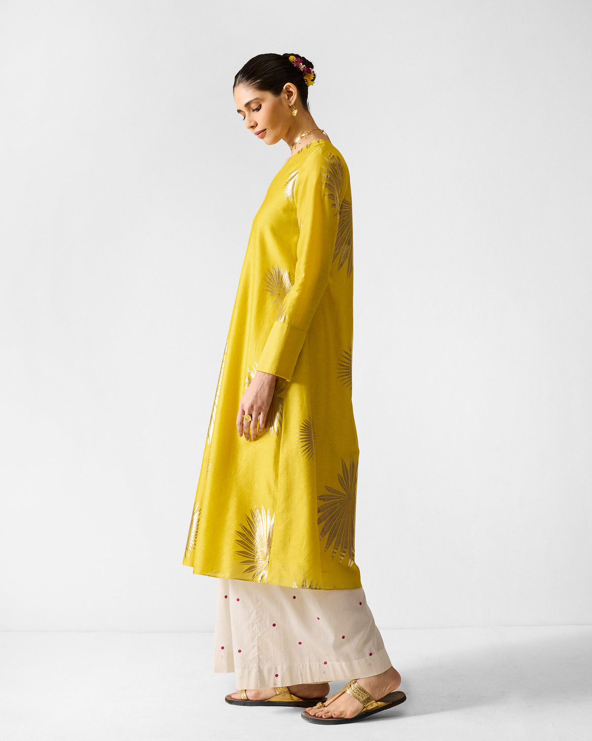 Side view of a chartreuse flared kurta with gold palm print motifs.