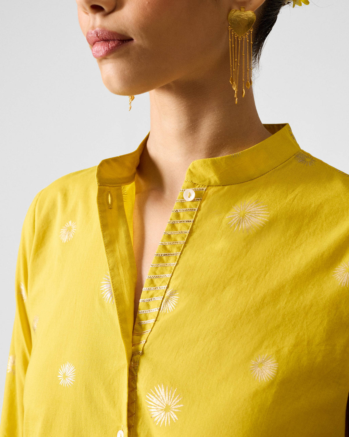Close-up of the mandarin collar and gold trim on a chartreuse kurta.