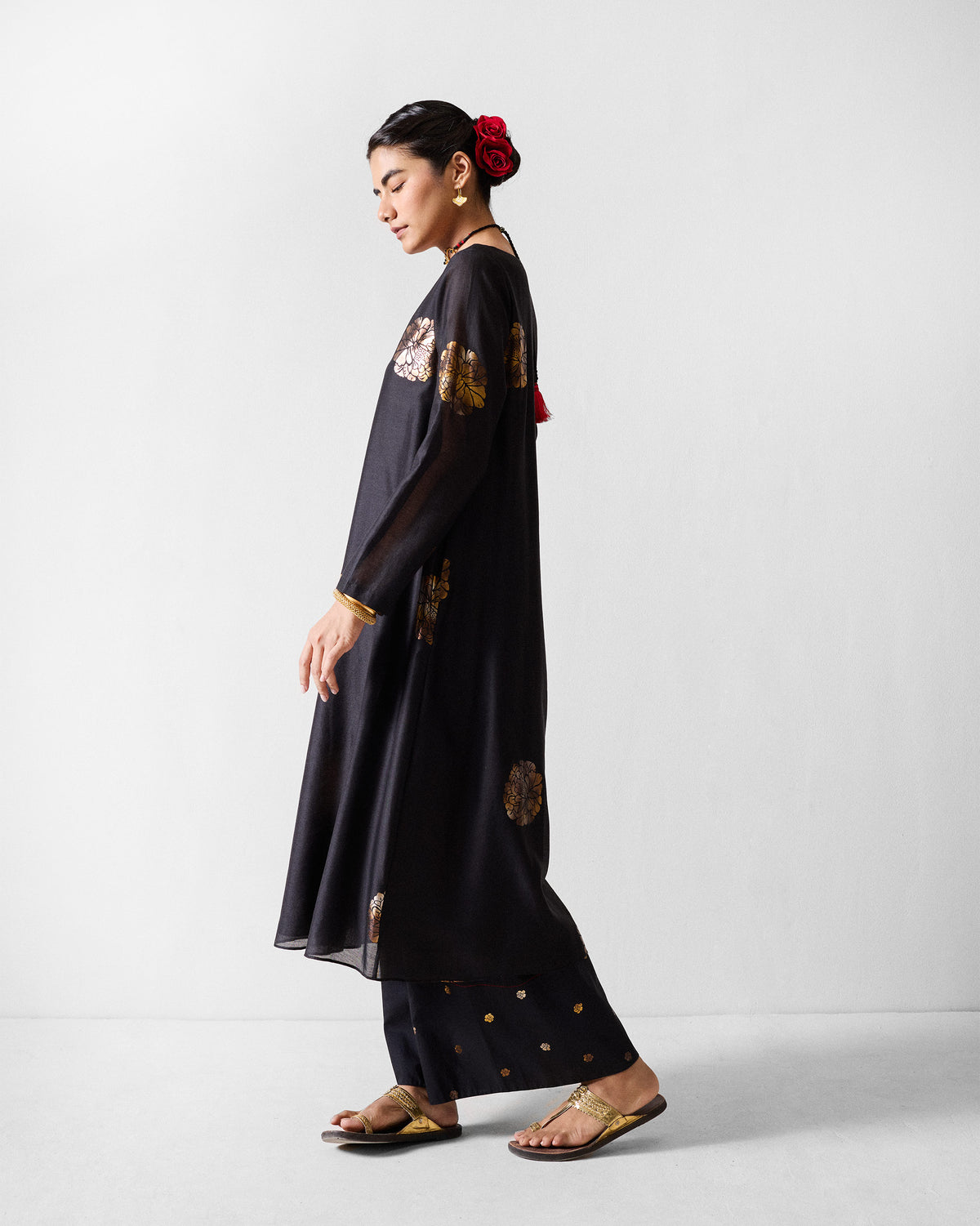 Side view of a black boat-neck kurta with gold foil florals.
