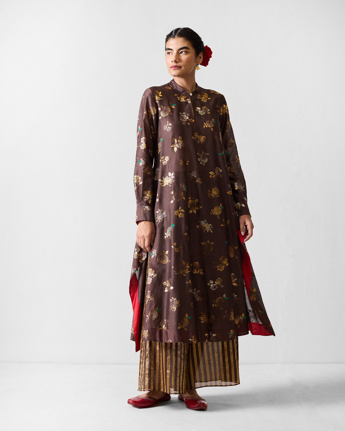 Person wearing a brown gold-print kurta with high side slits.