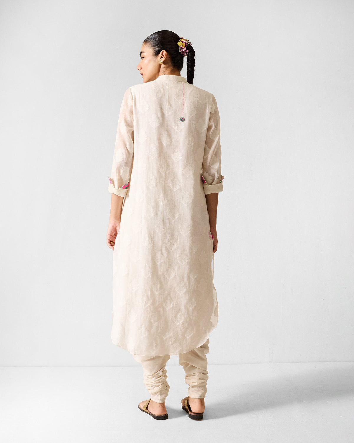 Back of an ivory long kurta with a tonal floral buta pattern.